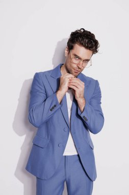 Modaya uygun esmer adamın portresi. Gri renkli kameraya bakıyor. 