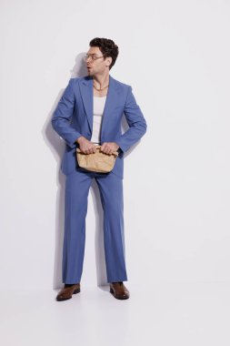 Kaliteli takım elbiseli, gözlüklü, elinde kağıt torba olan korkak bir adam. 