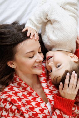 Örgü örmüş süveter giymiş gülümseyen bir çocuğun portresi. Evde, annemin yanında yatıyordu.