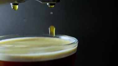 Siyah zemin üzerine makine portafiltresinden dökülen kahveyi kapat.