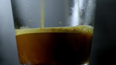 Koyu arkaplanda şeffaf bardaklara dökülen kahveyi kapat.