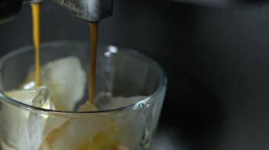 Makineden dökülen kahveyi buzlu bardakla kapat. 