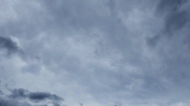 Koyu gri yağmurlu bulutların zaman akışı gökyüzünde ilerliyor