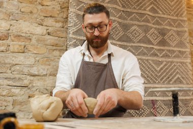 Çömlek atölyesinde önlük ustası kil oluşturur.