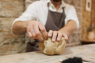 Bulanık çömlekçi stüdyoda çalışırken ıslak çamur alıyor.