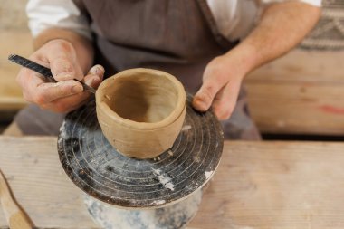 Esnaf, atölyede kil bardaktan bıçak yapıyor.