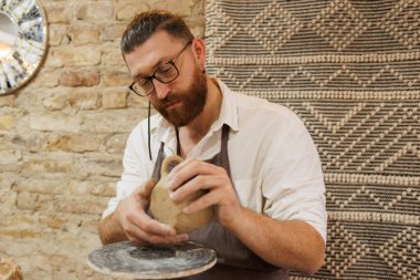 Çömlek atölyesinde kilden kupa yapmaya odaklı çömlekçi