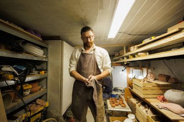 Esnaf atölyenin deposunda ellerini kurutuyor.