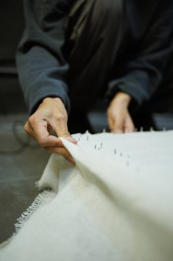 Çerçeveye halı bezi bağlayan zanaatkar kadın parçası