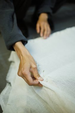 Çerçeveye halı nakışı yapan zanaatkar kadını kapatın.