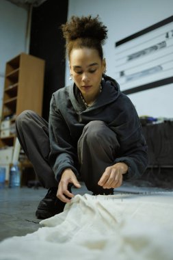 Afro-Amerikalı bir kadın halı nakış işiyle uğraşıyor.