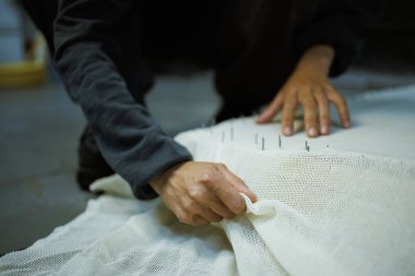 Çerçeveye çivili halı çeken zanaatkar kadını kapatın.