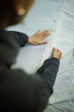 Atölyedeki halı tuvalini tamir ederken kısmen çekilmiş bir resim.