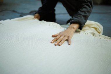 Halı brandasını çeken bir zanaatkar. 