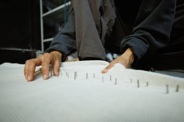 Çerçeveye çivili halı çeken zanaatkar kadını kapatın.