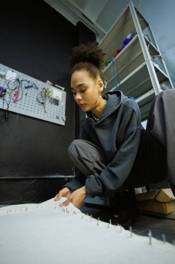 Afrikalı Amerikalı zanaatkar atölyedeki halı tabanını çerçeveye çekiyor