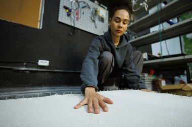 Afrikalı Amerikalı zanaatkar atölyedeki halı tabanını kontrol ediyor.