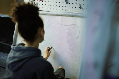 Bulanık Afrikalı Amerikalı zanaatkar halıyı tuvalle işaretliyor. 