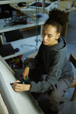 Afrikalı Amerikalı zanaatkar kadın halı nakışına resim çiziyor.