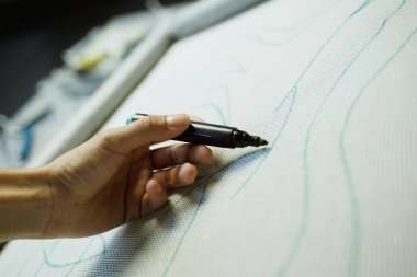 Halı tuvaline desenler çizen zanaatkar kadını kapat.