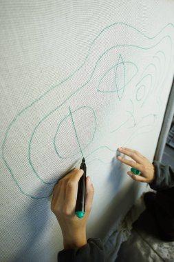 Zanaatkar kadının halıdaki tuvale çiziminin üst görüntüsü 