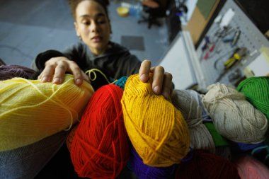 Afrikalı Amerikalı zanaatkar atölyede halı için kıyafet seçiyor.