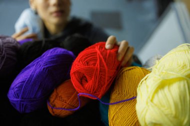 Afrika kökenli Amerikalı bir zanaatkar atölyede akrilik iplikler alıyor.