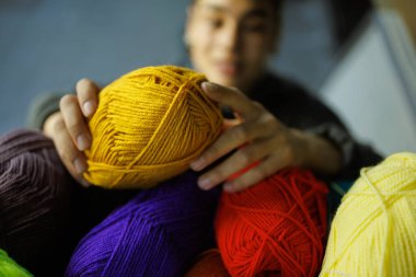 Bulanık Afrikalı Amerikalı zanaatkar raftan akrilik iplikler alıyor.