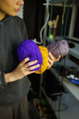 Afrikalı Amerikalı zanaatkar kadın halı için iplik tutuyor. 