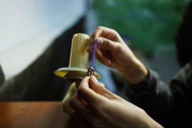Zanaatkar kadının, top camında yuvarlanan akrilik iplik görüntüsü.