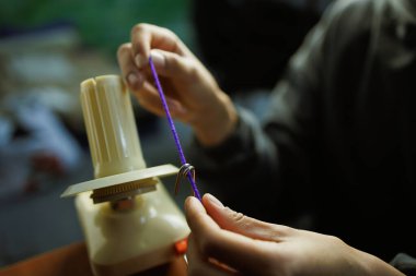 İplik topu Winder kullanan bulanık zanaatkar kadını kapat.