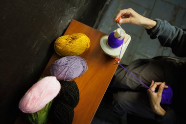 Zanaatkar kadının yanındaki iplik topu Winder kullanan ipliklerin üst görünümü