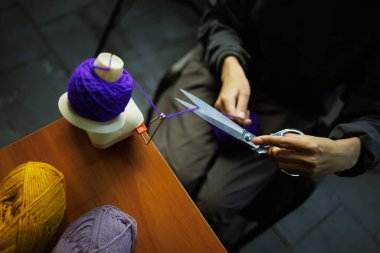 Top camında iplik kesen zanaatkar kadının üst görüntüsü