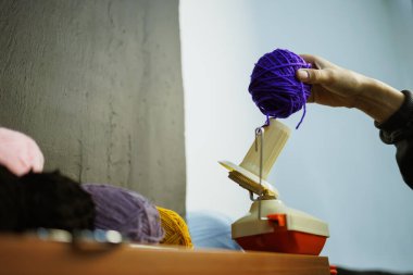 Atölyede Winder 'dan iplik alan zanaatkar bir kadın.