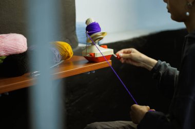 Zanaatkar kadının top camında yuvarlanan ipliği.