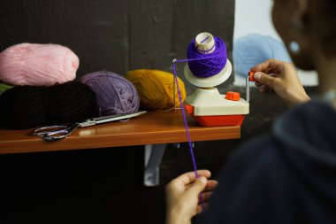 Zanaatkar kadın atölyedeki ipliklerin yanında top camında yuvarlanıyor.
