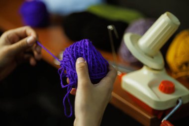 Zanaatkar kadın iplik tutuyordu. Bulanık top camının yanında.