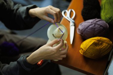 İplikler için iplik topunu kullanan usta kadının üst görünümü 