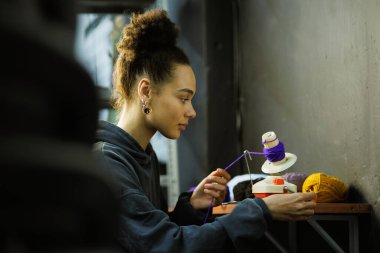 Afrikalı Amerikalı zanaatkar atölyede örgü örüyor.