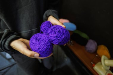 Atölyede örgü ipliği tutan zanaatkar kadına yaklaş.