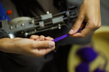 Elinde iplik ve halı çekme makinesi olan zanaatkar kadını kapatın. 