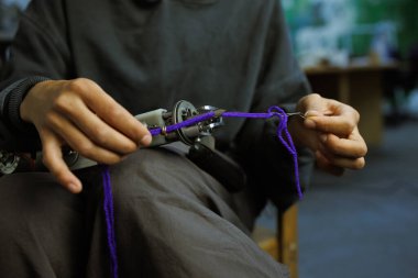 Halı çekme makinesinde ipliği dolduran zanaatkar kadın parçası. 