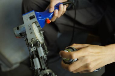 Halı çekme silahına silikon yağı süren bir kadın. 