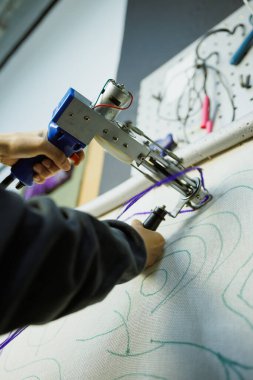 Atölyede halıyı çerçeveli yapan kadın.