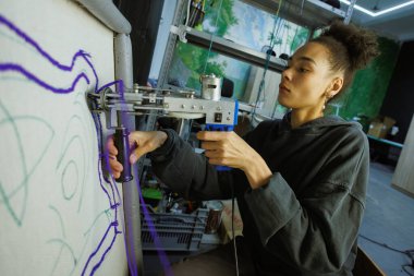 Afrikalı Amerikalı zanaatkar atölyede çerçeve üzerinde halı yapıyor.