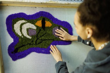 Bulanık Afrikalı Amerikalı zanaatkar el yapımı halıyı kontrol ediyor. 