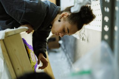 Afrikalı Amerikalı bir zanaatkar çerçeveyi tuvalde tutuyor.