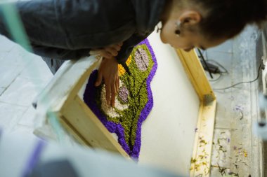 Afrikalı Amerikalı bir zanaatkar çerçeveyi tuvalde tutuyor.