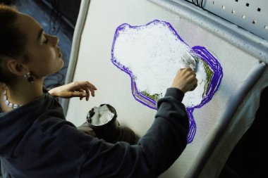 Afrikalı Amerikalı bir zanaatkar halıya yapıştırıcı sürüyor.