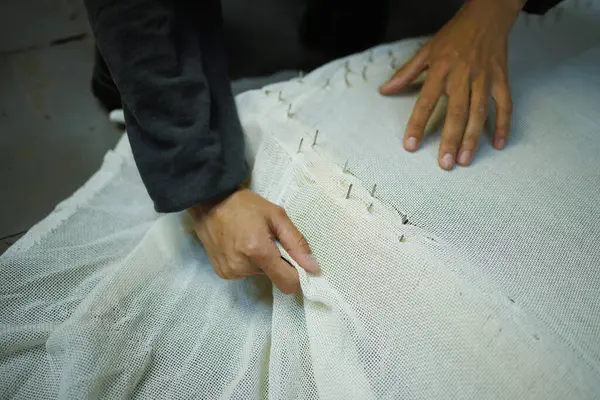 Çerçeveye halı bezi bağlayan zanaatkar kadının kısmi çekimi